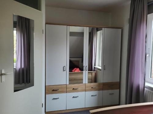 a large white cabinet with a mirror in a bedroom at Ferienhaus Seeperle in Tossenserdeich