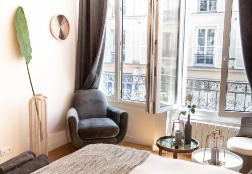un salon avec une chaise et une fenêtre dans l'établissement The Charming Rue Cler, à Paris