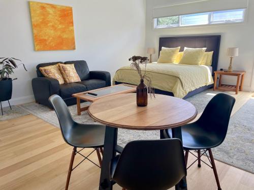 a living room with a bed and a table and chairs at Port Fairy BNB - The Yellow Suite in Port Fairy