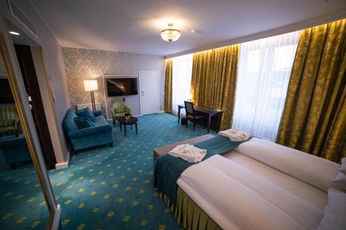 a hotel room with a bed and a living room at Hotel Bristol in Oslo
