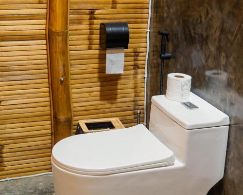 a toilet with a roll of toilet paper on top of it at The Backyard Inn in Moalboal