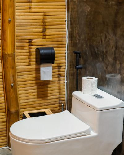 a toilet with a roll of toilet paper on top of it at The Backyard Inn in Moalboal