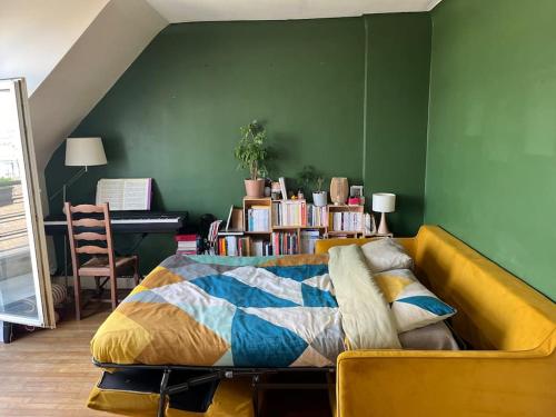 - une chambre avec un lit jaune et un mur vert dans l'établissement Balcony with view of Montmartre, à Paris