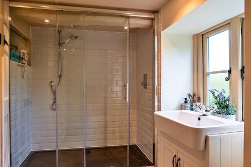 a bathroom with a shower and a sink at Finest Retreats - The Thatch at Winterborne Houghton in Winterborne Stickland