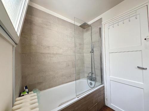une salle de bain avec baignoire et douche en verre dans l'établissement Balcony with view of Montmartre, à Paris