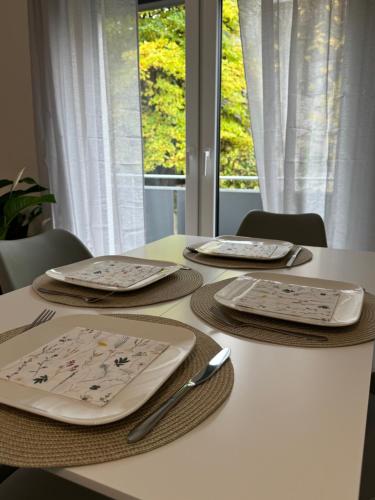 a white table with plates and utensils on it at City Residenz , Europa-Park - Rulantica in Lahr