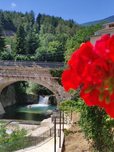 a bridge over a river with a red flower at A casa di zia Maly in Palena
