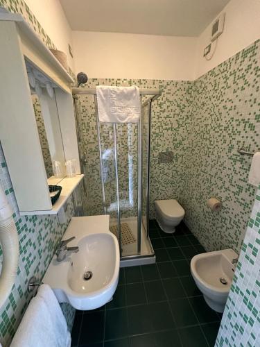 a bathroom with a sink and a shower and a toilet at Hotel Svizzera in Arma di Taggia