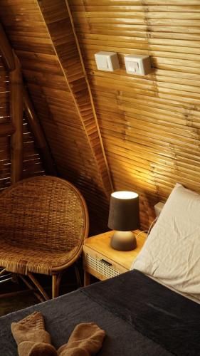 a bedroom with a bed and a lamp and a chair at The Backyard Inn in Moalboal