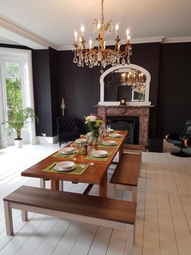 a dining room with a table and a chandelier at Beautiful Pendine Manor House in West Wales in Pendine