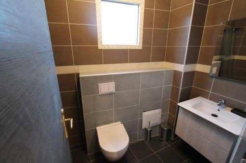 a bathroom with a toilet and a sink and a window at Residence MASSOU in Yaoundé