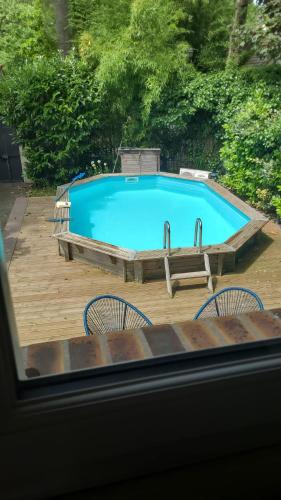 une grande piscine bleue avec des chaises et une table dans l'établissement Le CHALET, à Créteil
