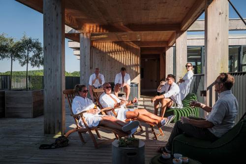 a group of people sitting in chairs on a porch at Hotel GSH in Rønne