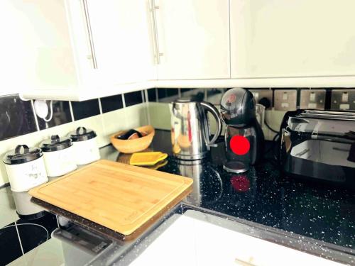 a kitchen counter with a cutting board on a counter top at City Mill - Next to Town Centre Shopping and Restaurants - Free Parking in Burton upon Trent