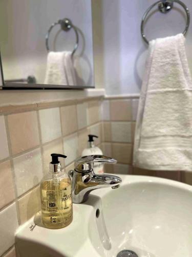 a bathroom sink with a soap dispenser on it at City Mill - Next to Town Centre Shopping and Restaurants - Free Parking in Burton upon Trent
