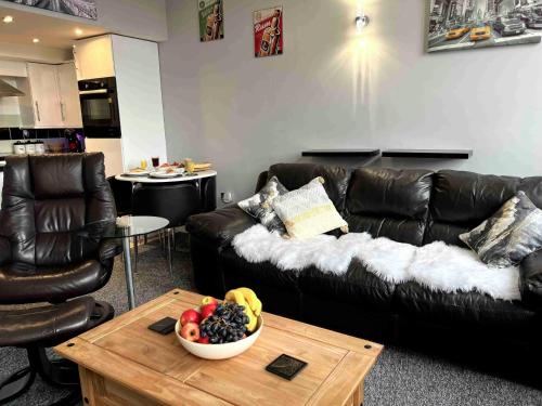 a living room with a couch and a bowl of fruit on a table at City Mill - Next to Town Centre Shopping and Restaurants - Free Parking in Burton upon Trent