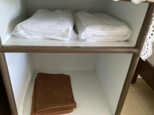 two white towels are sitting on a shelf at Hotel M Rojana Ayutthaya in Ban Sang