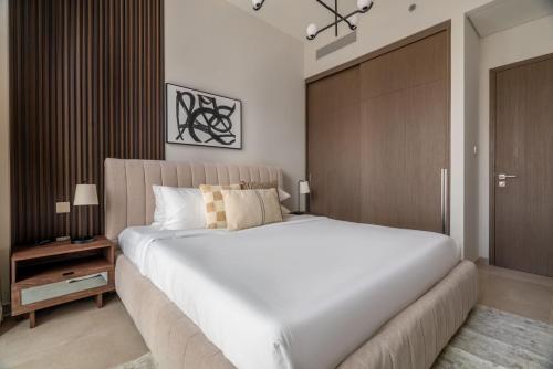 a bedroom with a large white bed and a closet at GuestReady - Elegant 1BR l Premium Amenities in Dubai