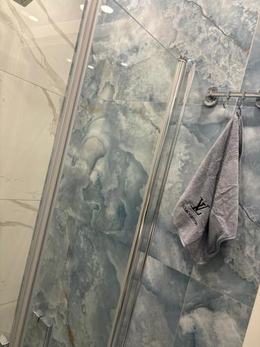 a shower with a glass door and a towel at Aurora House 2 in Naples