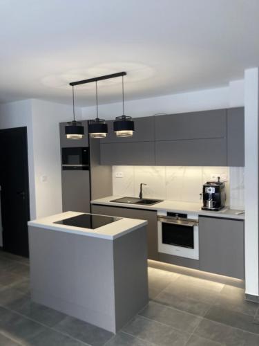 a kitchen with white cabinets and a counter top at Swiss Star Apartment in Mosonmagyaróvár