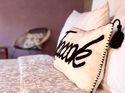 a pillow with the word hug sits on a bed at Teacook Marrakech in Ouled el guerne