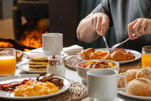 a table with plates of breakfast food on it at Dolinas Climbing Hotel in Porto de Mós