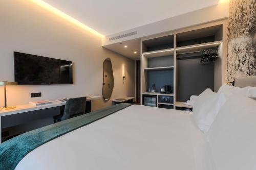 a hotel room with a bed and a desk at Dolinas Climbing Hotel in Porto de Mós