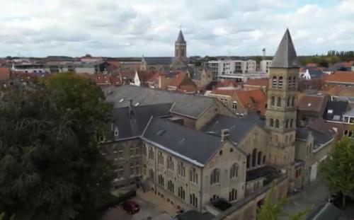 an aerial view of a city with a church at The Carmelite in Ypres