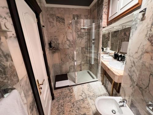 a bathroom with a shower and a sink and a toilet at Alhambra Suites in Madrid
