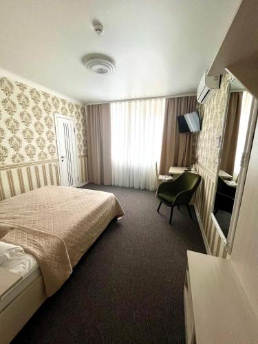a hotel room with a bed and a desk at Готель Лаванда in Khmelʼnytsʼkyy
