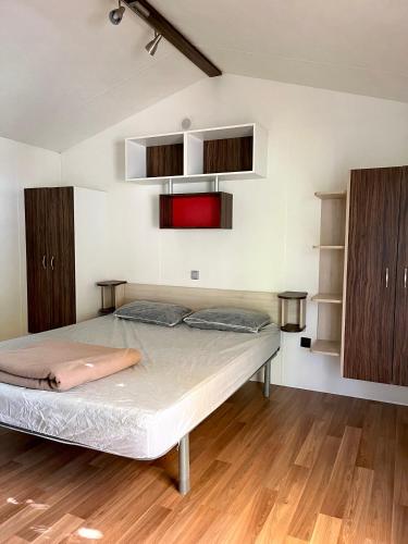 Ce lit se trouve dans un dortoir doté de parquet et d'armoires. dans l'établissement Mobil-home 2 chambres PMR - Camping la Faloise, à Angicourt