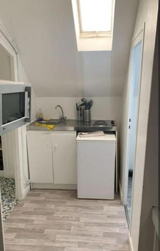 une petite cuisine avec un évier et une cuisinière dans l'établissement Le Petit Tourangeau, à Tours