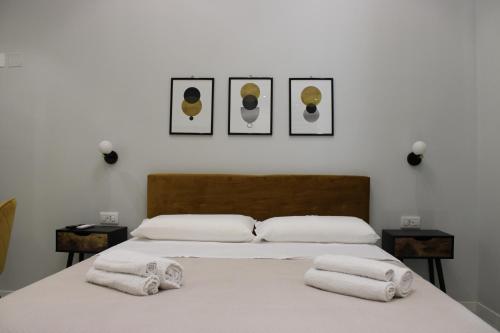 a bedroom with a bed with three pictures on the wall at InCentro Elegant Rooms in Messina