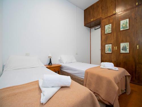 a bedroom with two beds and a wooden wall at Apartamentos 3000 Escarrilla in Escarrilla