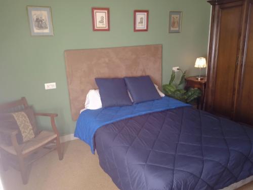 a bedroom with a large blue bed and a chair at Apartamentos 3000 Escarrilla in Escarrilla