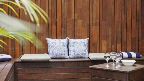 a wooden bench with pillows and wine glasses on it at Boronia Oasis - Tranquil Oasis By The Creek, Sleeps 4 in Sawtell