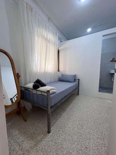 a bedroom with a bed with a window and a mirror at Private Room in San Ġwann