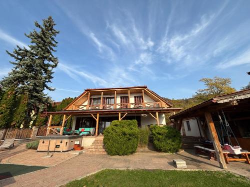 a large house with a porch and a house at Parti Apartman in Balatonfůzfő