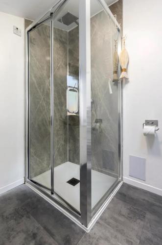 a shower with a glass door in a bathroom at Beach room in Ayr