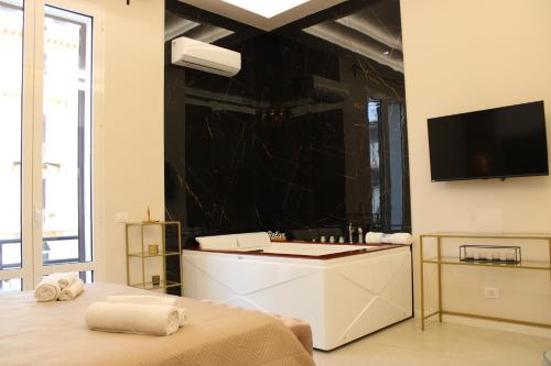 a bedroom with a television and a bed with towels at InCentro Elegant Rooms in Messina