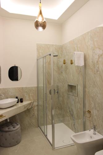 a bathroom with a shower and a toilet and a sink at InCentro Elegant Rooms in Messina