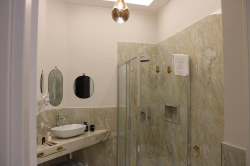 a bathroom with a glass shower and a sink at InCentro Elegant Rooms in Messina