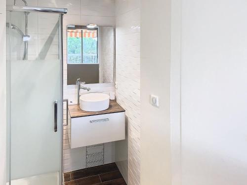 La salle de bains est pourvue d'un lavabo et d'une porte de douche en verre. dans l'établissement Superbe appartement terrasse vue mer 347L GLEN, à Cannes