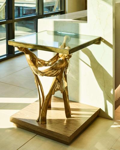 a glass table with a person sitting on a wooden base at Lively Hotel On Oak Oklahoma City, Tapestry By Hilton in Oklahoma City
