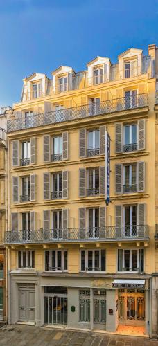 a large yellow building with a lot of windows at Hôtel de Roubaix in Paris