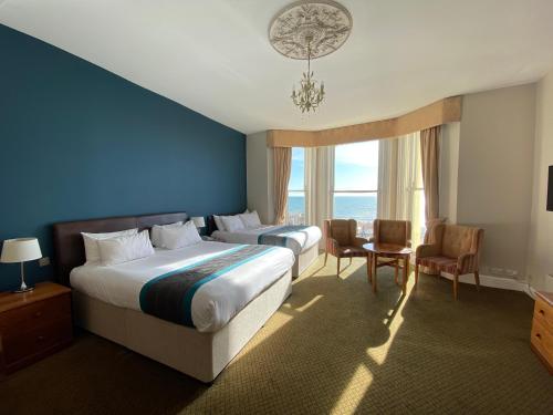 a hotel room with two beds and a large window at Queens Hotel & Spa in Brighton & Hove