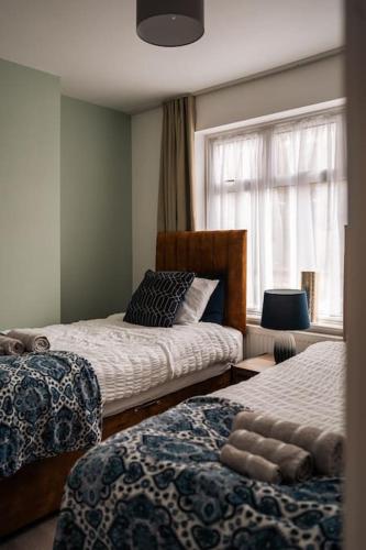 a bedroom with two beds and a window at Contractor-Friendly 3-Bed, Games Room, Pool Table! in Enfield Lock