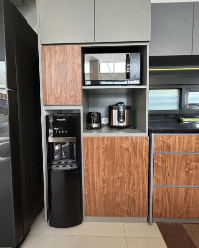 a kitchen with a black refrigerator and a microwave at Royal Hill Villa Cisarua Puncak in Puncak