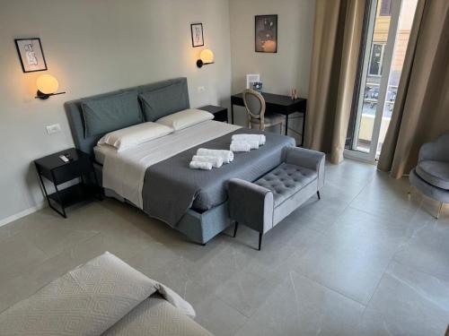 a bedroom with a bed and a chair and a table at InCentro Elegant Rooms in Messina