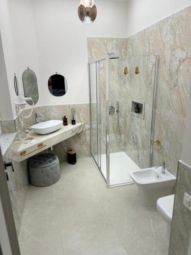 a bathroom with a shower and a toilet and a sink at InCentro Elegant Rooms in Messina